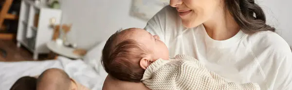Hermosa madre feliz mirando alegremente a su lindo bebé recién nacido, concepto de familia, bandera - foto de stock
