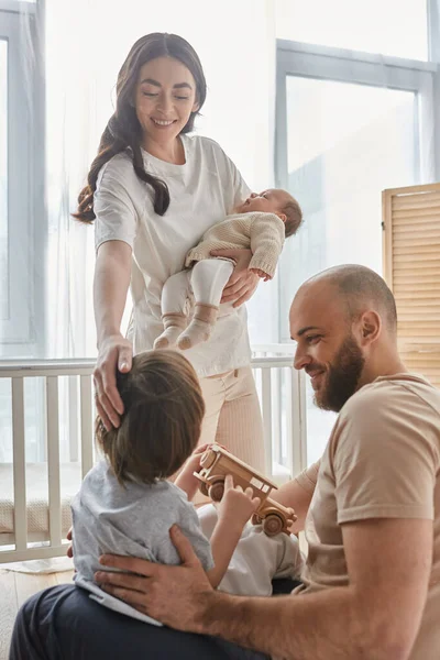 Vertical shot of modern young family in casual homewear having good time together, modern parenting — Stock Photo