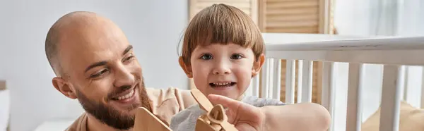Jolly cute boy playing with wooden plane with his father smiling at camera, family concept, banner — Stock Photo