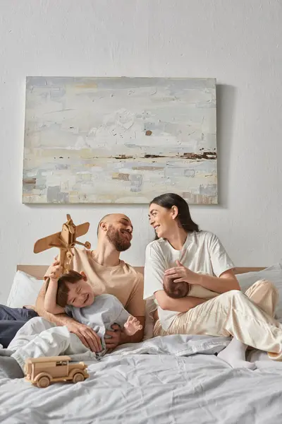 Vertikale Aufnahme moderner Eltern, die sich glücklich anschauen, wenn sie Zeit mit ihren Kindern verbringen — Stockfoto