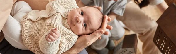 Mignon nouveau-né garçon couché dans les bras de son père et regardant la caméra, concept de famille, bannière — Photo de stock