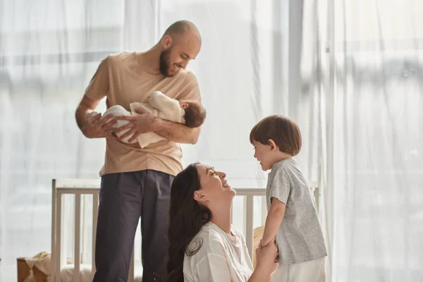 Jolly beautiful family of four in cozy homewear spending time together happily, modern parenting — Stock Photo