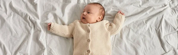 Draufsicht auf entzückendes Neugeborenes im Liegen zu Hause mit leicht erhobenen Armen, Banner — Stockfoto