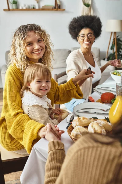 Happy multiethnic relatives holding hands and praying at Thanksgiving table, grateful for meal — Stock Photo