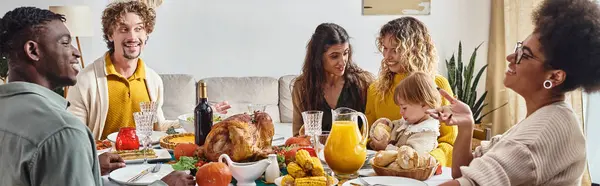 Happy multiracial family and friends talking and smiling during Thanksgiving dinner, festive banner — Stock Photo