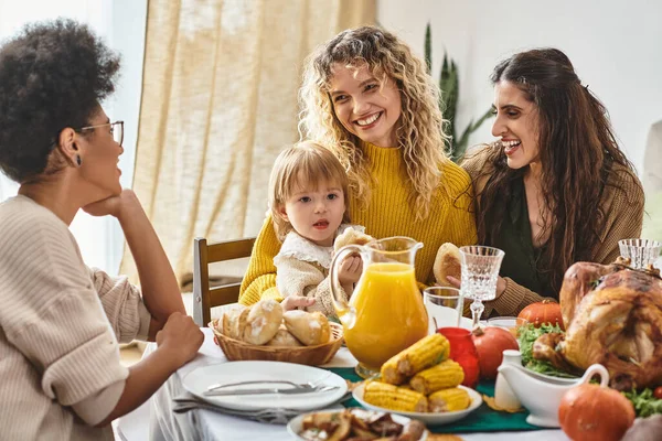 Glückliche multiethnische Frauen sprechen in der Nähe von Kleinkind Mädchen während Thanksgiving-Feier, Festtag — Stockfoto