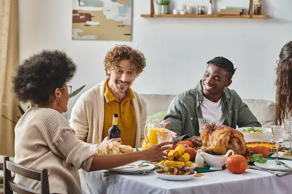 Happy multiethnic family and friends talking while having Thanksgiving dinner, festive occasions — Stock Photo