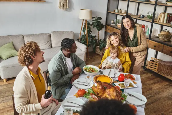Celebración de Acción de Gracias, amigos interracial y familia cenando juntos, familia lgbt - foto de stock