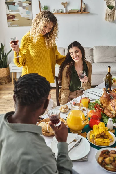 Joyful lgbt family celebrating Thanksgiving with toddler baby girl, cheering and smiling at home — Stock Photo