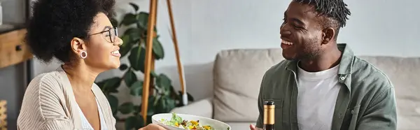 Heureuse femme afro-américaine passant bol avec salade à parent pendant le dîner de Thanksgiving, bannière — Photo de stock