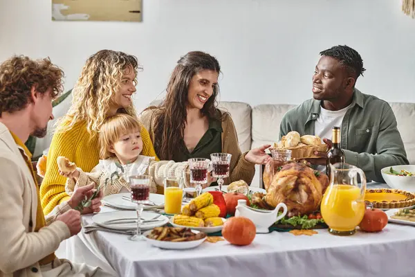 Happy african american man passing baked buns to friends during Thanksgiving dinner, turkey day — Stock Photo