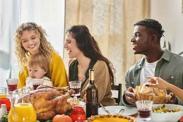 Жареная индейка в центре стола, счастливая межрасовая семья празднует День Благодарения вместе — стоковое фото