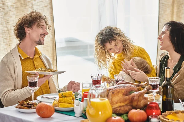 Happy multiracial family enjoying delicious dinner while gathering on Thanksgiving, roasted turkey — Stock Photo