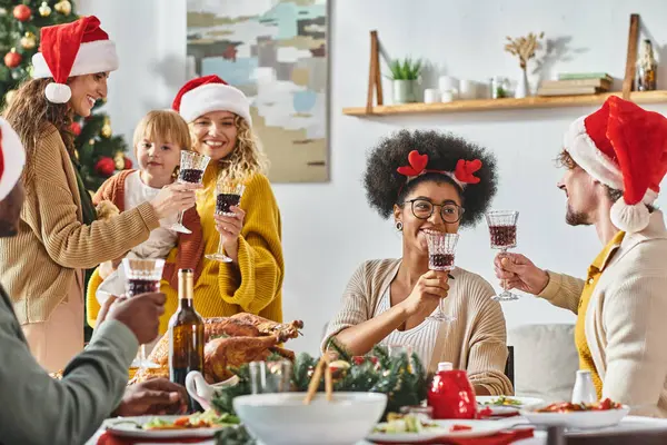 Concepto de vacaciones de invierno, familia multiétnica alegre y amigos celebrando la Navidad juntos - foto de stock