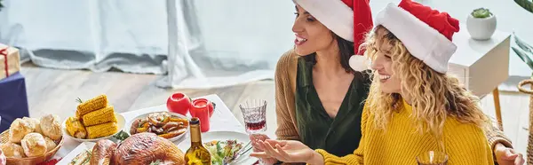Cheerful lgbt couple smiling and talking to other family members sitting at festive table, banner — Stock Photo