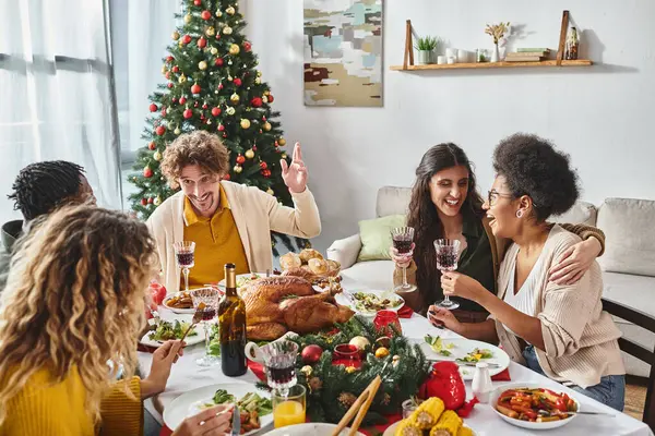 Happy multicultural relatives celebrating Christmas together and enjoying festive lunch and wine — Stock Photo