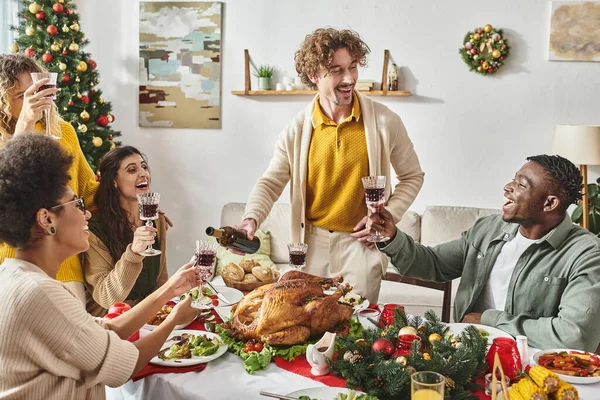 Grande alegre família multirracial tendo grande momento rindo e bebendo vinho, dia de Natal — Fotografia de Stock