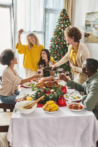 Big multiethnic family gathered at festive table enjoying each other and drinking wine, Christmas — Stock Photo