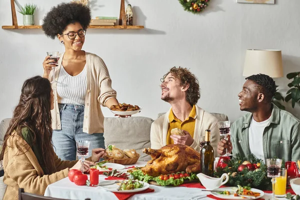 Joyous multicultural relatives looking and smiling at each other while enjoying Christmas feast — Stock Photo