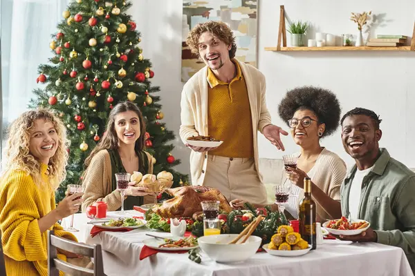 Allegra famiglia multiculturale godendo festa di festa con vino e sorridente alla macchina fotografica, Natale — Foto stock