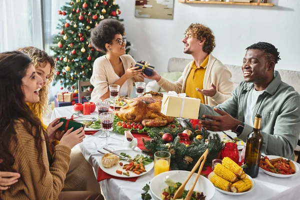 Grande famille joyeuse et multiraciale ayant beaucoup de temps pour célébrer Noël et échanger des cadeaux — Photo de stock