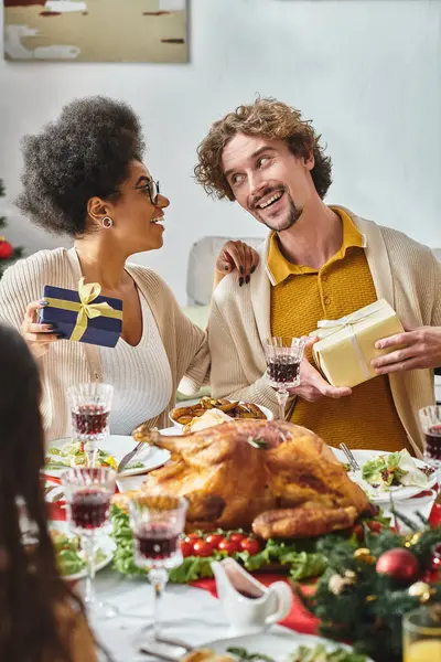 Due gioiosi parenti multietnici che si guardano e si sorridono, mano sulla spalla, Natale — Foto stock