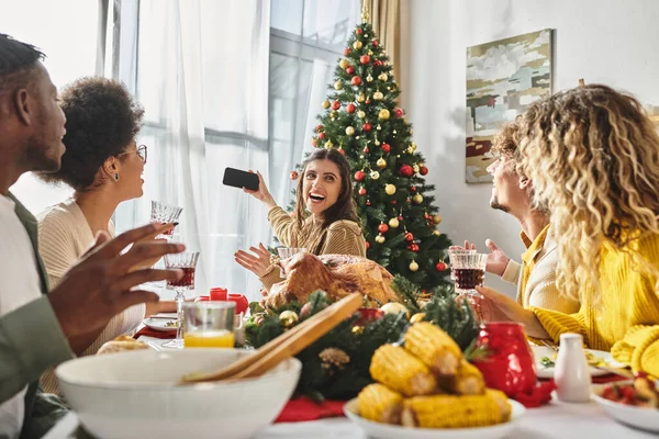 Multiethnic family members taking selfies while celebrating Christmas together at holiday feast — Stock Photo