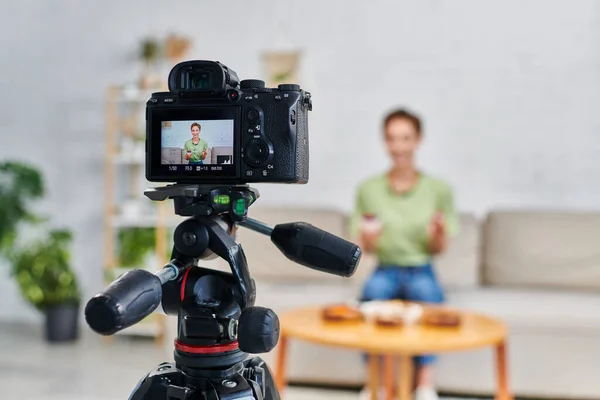 Selective focus of digital camera in front of vegetarian video blogger describing plant-based diets — Stock Photo