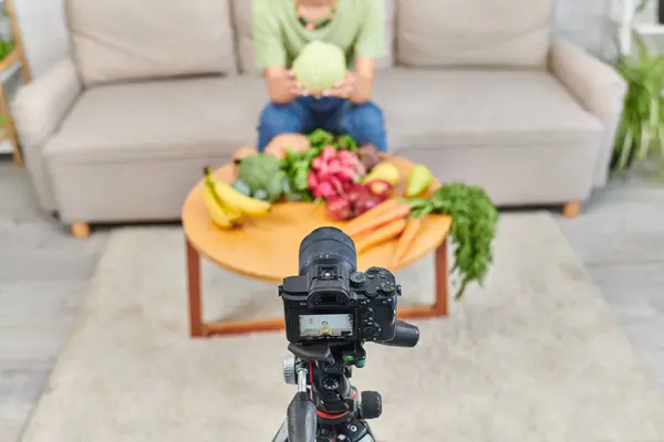 High angle view of digital camera near cropped woman with plant origin products during video blog — Stock Photo