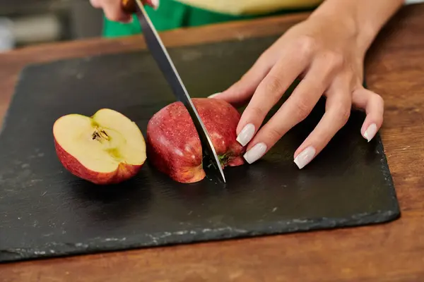 Cropped view of woman cutting fresh ripe apple on chopping board, vegetarian meal home preparation — Stock Photo