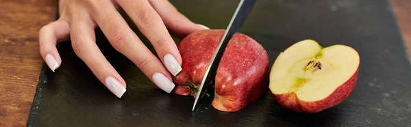 Visão parcial da mulher vegetariana cortando maçã madura fresca na tábua de corte, bandeira horizontal — Fotografia de Stock
