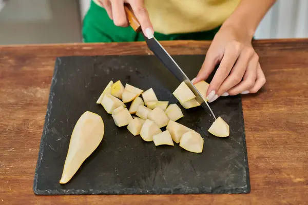 Vista cortada de mulher com faca de corte fresco pêra madura em tábua de corte, culinária vegetariana — Fotografia de Stock