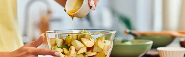 Обрезанный вид на вегетарианку, наливающую мед в стеклянную миску с вкусным фруктовым салатом, баннером — стоковое фото