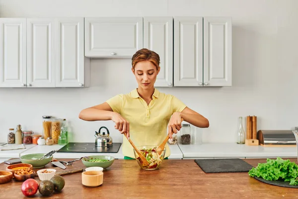 Mulher vegetariana misturando salada de frutas frescas na cozinha moderna, conceito de alimentação saudável e saudável — Fotografia de Stock