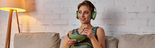 Mulher feliz sentada com tigela de comida vegetariana e ouvir música em fones de ouvido, banner — Fotografia de Stock
