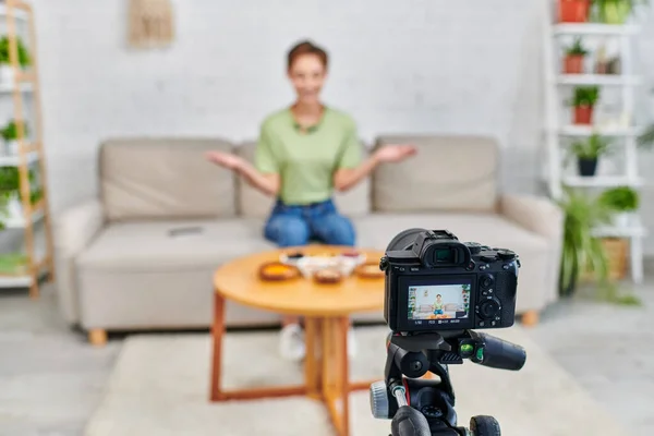 Selective focus of digital camera in front of woman talking during vegetarian culinary video blog — Stock Photo