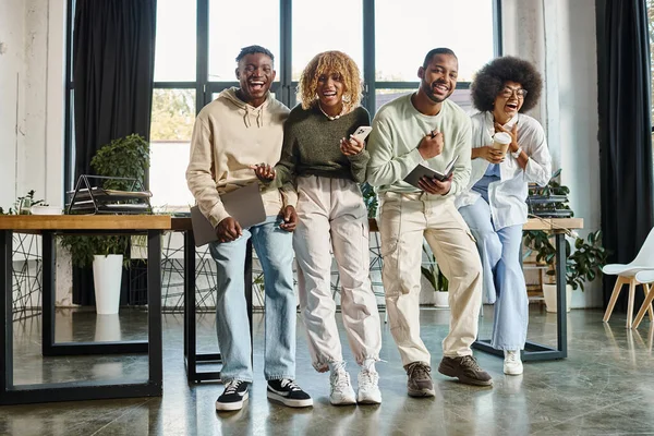 Fröhliche afrikanisch-amerikanische Freunde, die herzlich lachen, während sie an Projekt, Geschäftskonzept arbeiten — Stockfoto