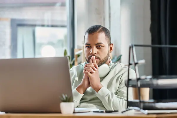 Thoughtful young man looking seriously at his laptop with fingers near face, working process — Stock Photo