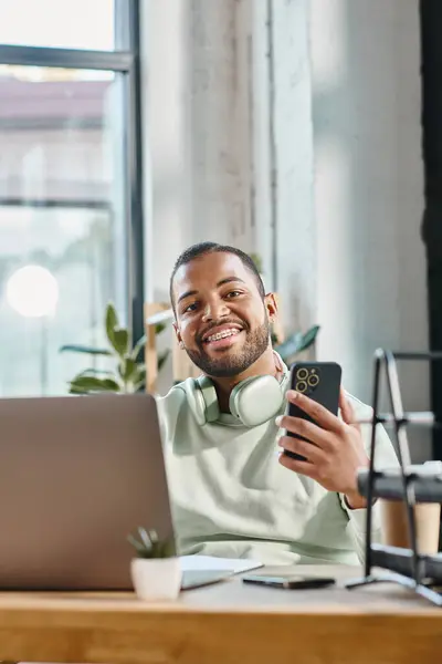 Porträt eines gut aussehenden Mannes mit Zahnspange in urbaner Kleidung mit Telefon und Laptop, Arbeitsprozess — Stockfoto