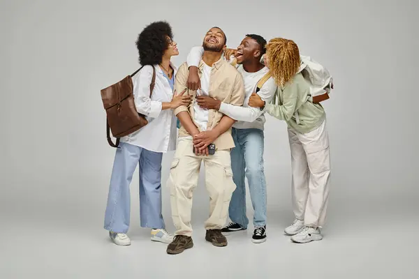 Amigos americanos africanos alegres que têm bom tempo posando em pano de fundo cinza, estilo de vida estudantil — Fotografia de Stock