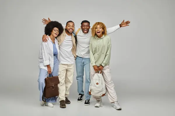 Young african american friends in casual wear with backpacks smiling cheerfully at camera, students — Stock Photo