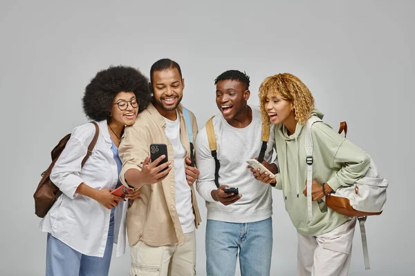 Young handsome man showing to his friends something cheerful on his phone, student lifestyle — Stock Photo
