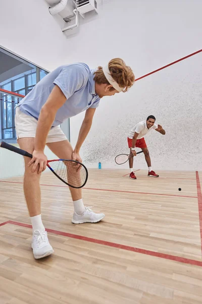 Fatigués joueurs interraciaux en vêtements de sport respirant lourdement après avoir joué au squash au tribunal, motivation — Photo de stock