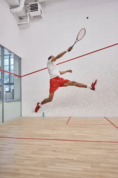 Motion shot, joueur afro-américain actif tenant une raquette tout en sautant et en jouant au squash — Photo de stock