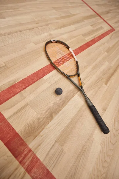 Raquette de balle et de squash sur le sol à l'intérieur du court intérieur, concept de motivation et de détermination — Photo de stock
