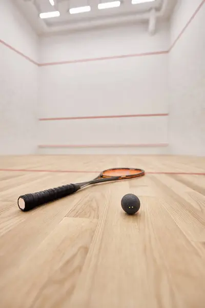 Squash ball and racquet inside of court with white walls, motivation and determination concept — Stock Photo