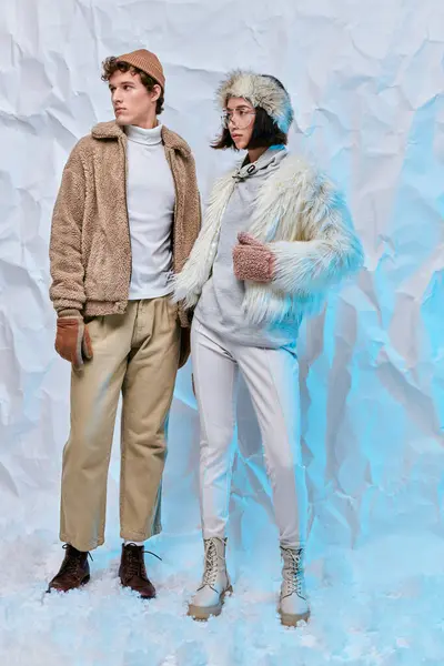 Comprimento total de modelos de moda interracial em desgaste frio posando no fundo branco amassado — Fotografia de Stock