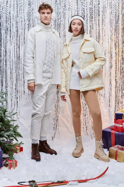 Models blicken in die Kamera neben Weihnachtsbaum und Geschenke auf silbernem Lametta-Hintergrund — Stockfoto
