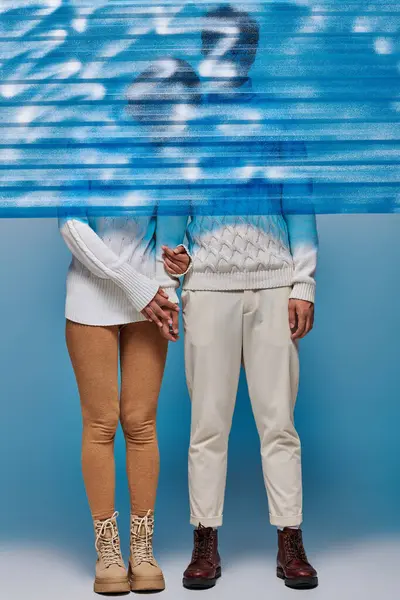Comprimento total do casal em camisolas brancas e botas de couro atrás de plástico congelado azul, estilo de inverno — Fotografia de Stock