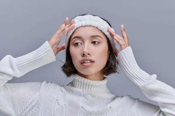 Stylische Asiatin im Strickpullover, warmes Stirnband auf grau, Wintermodefotografie — Stockfoto